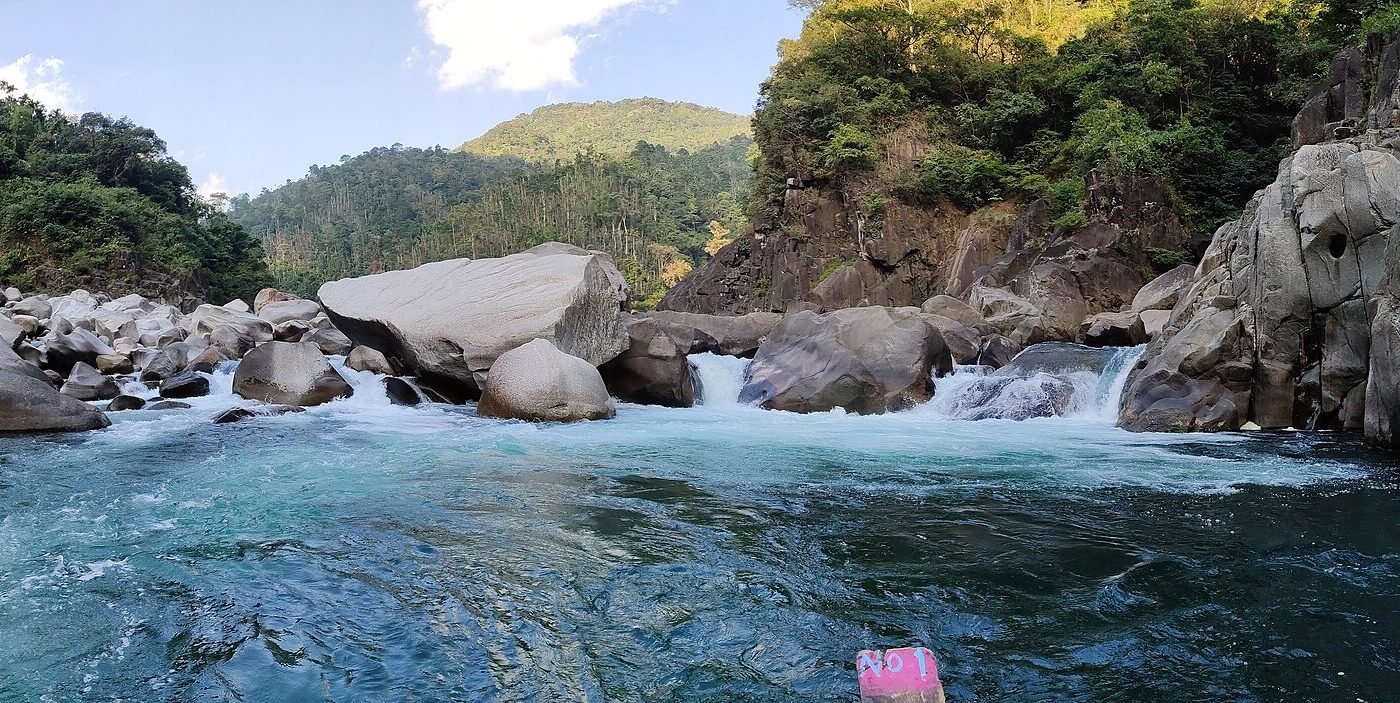 The clear Umngot River at Dawki, Meghalaya, with a wooden boat on the water