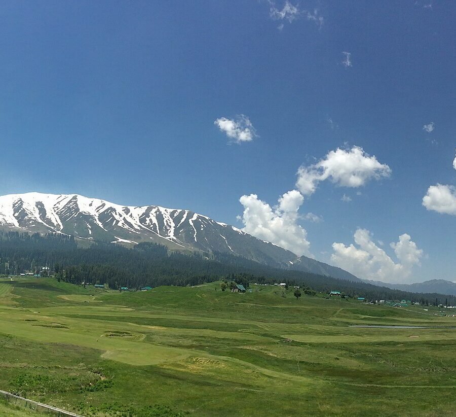 The meadows above Gulmarg in Kashmir under snow covered slopes